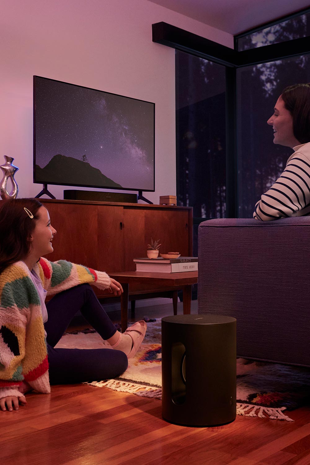 Family watching TV. Sonos speakers on the floor and with TV