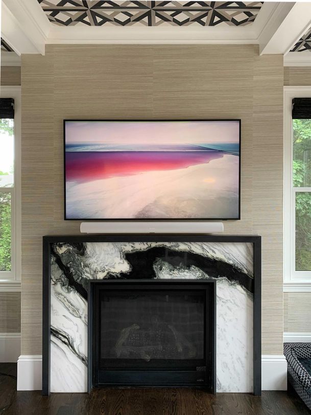 Stylish living room with a marble fireplace, a mounted TV, and modern decor.