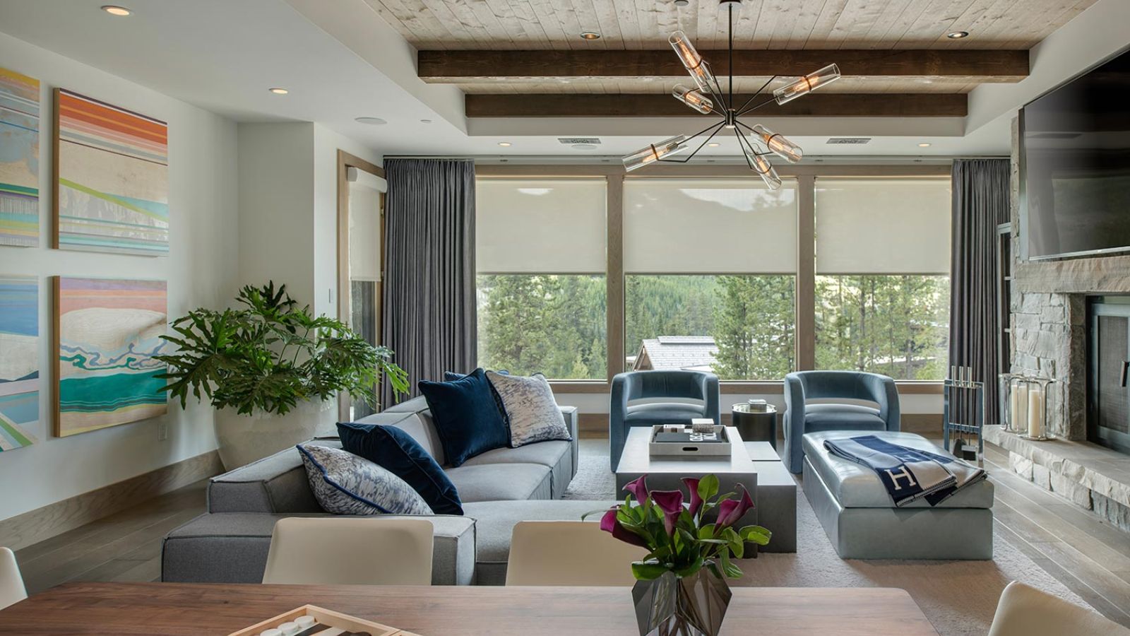 Contemporary living room with large windows, wood beam ceiling, and comfortable seating