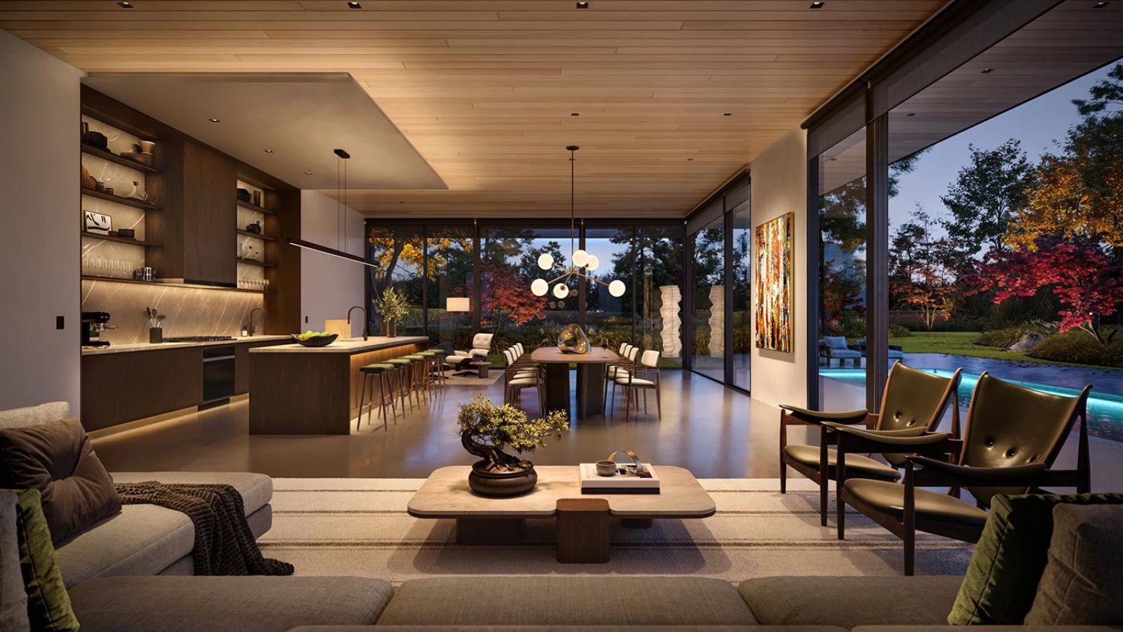 Modern open living space with kitchen, dining area, and large glass walls facing a landscaped yard