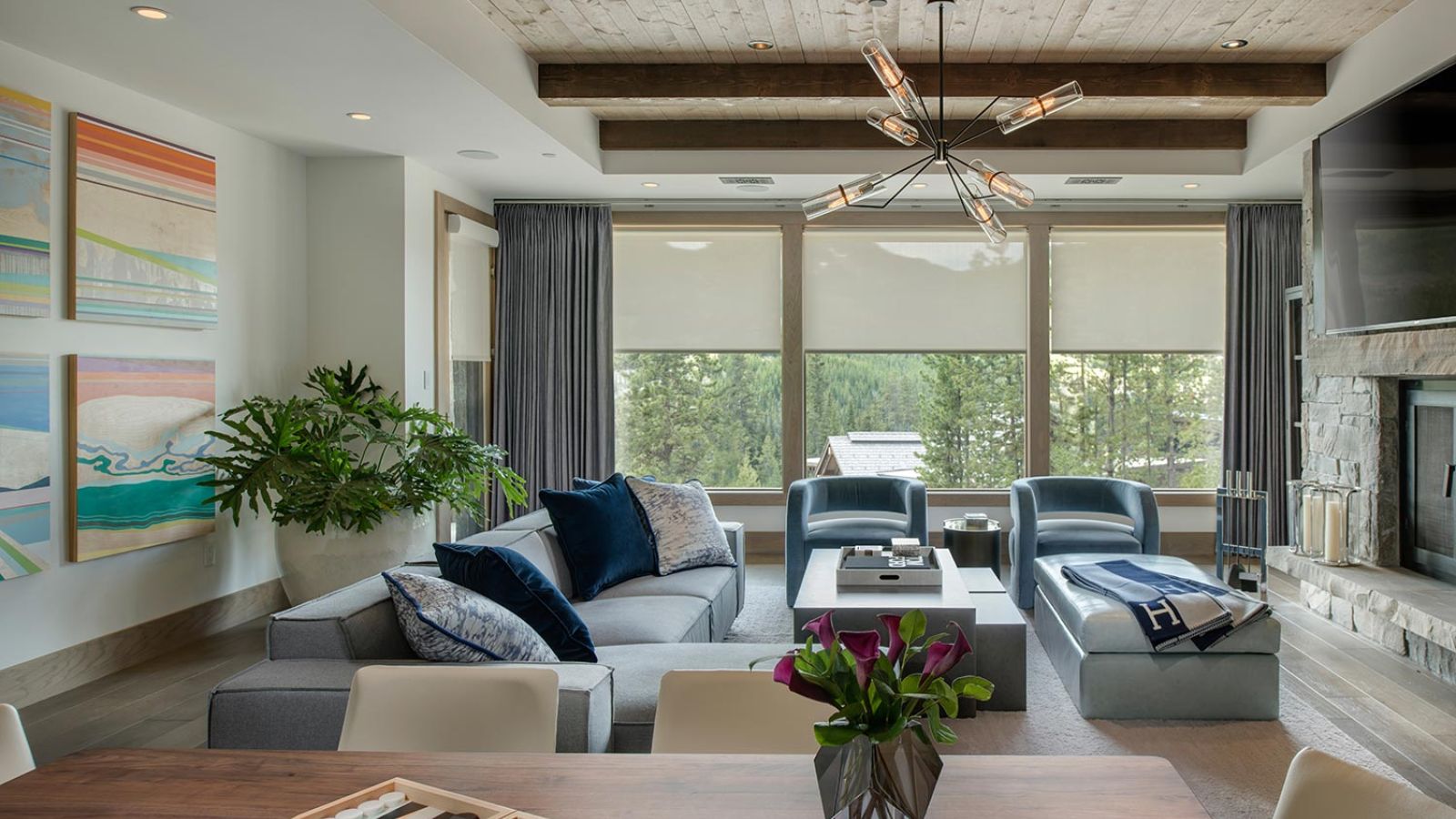 Contemporary living room with large windows, wood beam ceiling, and comfortable seating